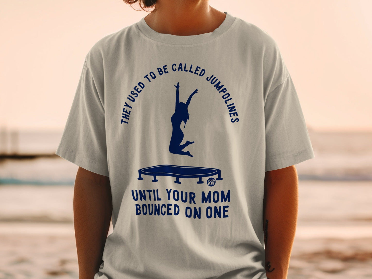 T-shirt with graphic of person jumping on trampoline and text "Until your mom bounced on one".
