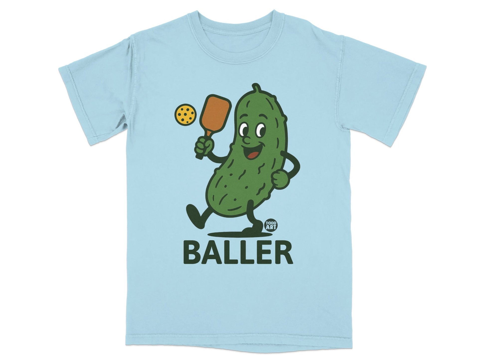 Light blue t-shirt with cartoon pickle playing pickleball, "FOOD ART BALLER" text.