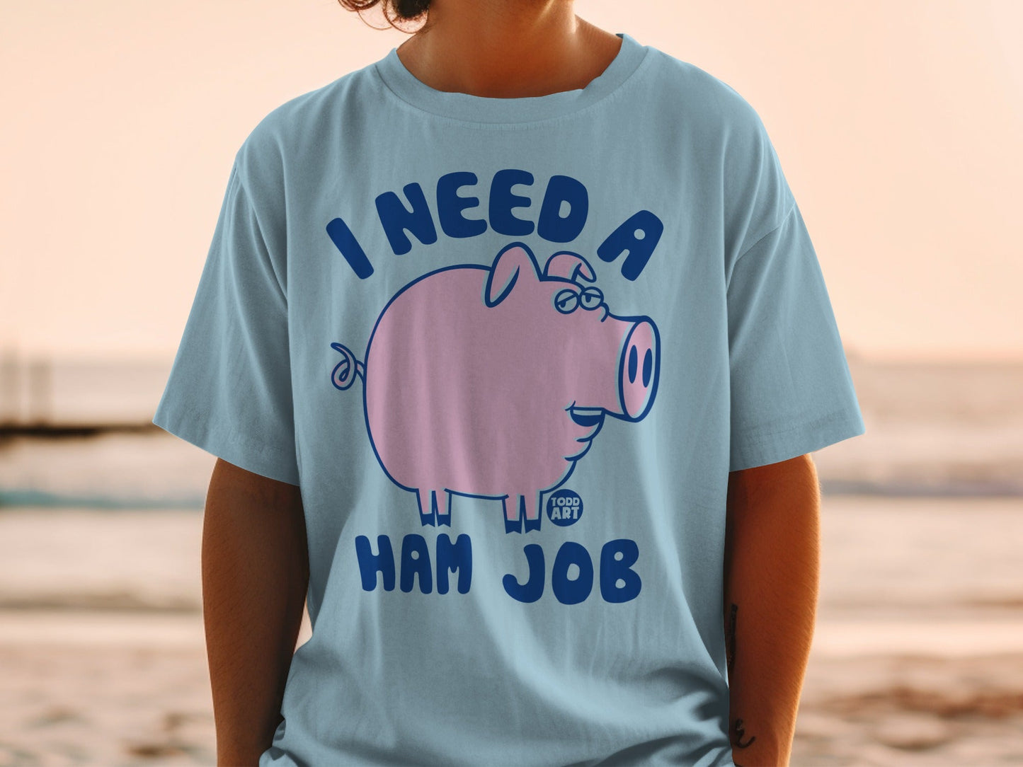 Blue t-shirt with a cartoon pig and text "I NEED A HAM JOB".