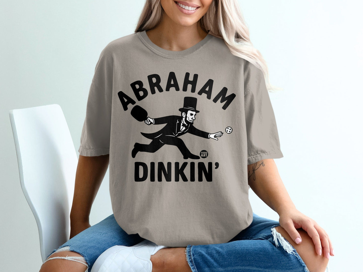 T-shirt with "Abraham Dinkin'" text and a cartoon Abraham Lincoln playing tennis.