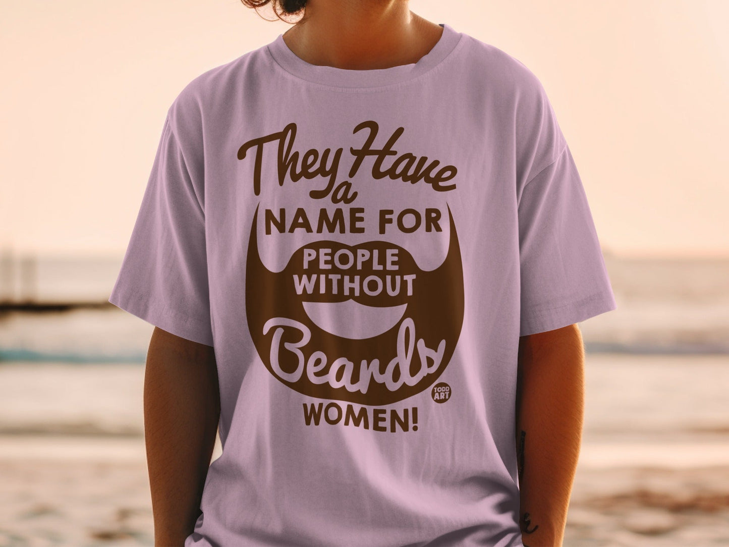 Light purple t-shirt with brown text "They Have a Name for People Without Beards: WOMEN!"