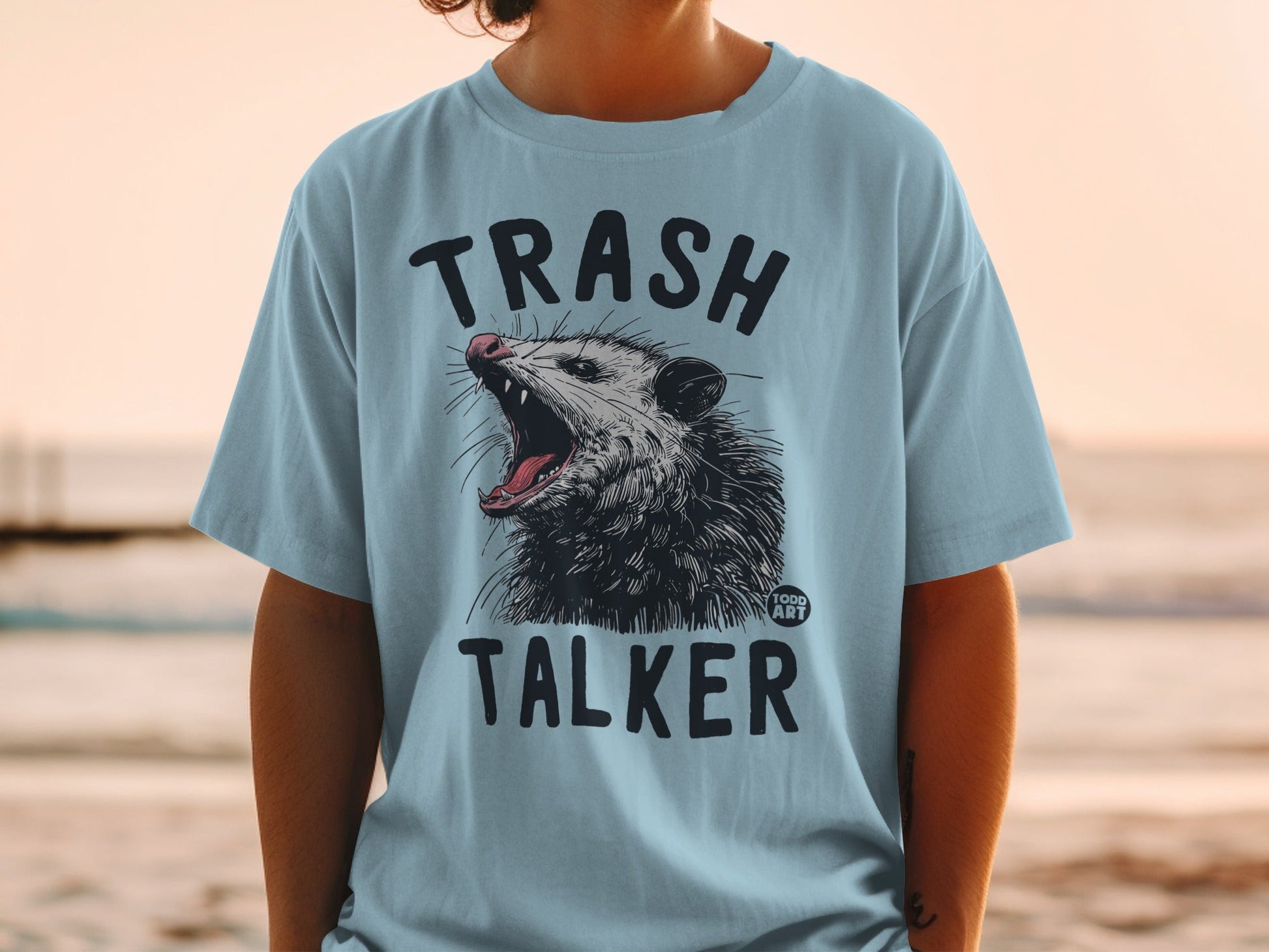 Light blue t-shirt with opossum graphic and "TRASH TALKER" text.