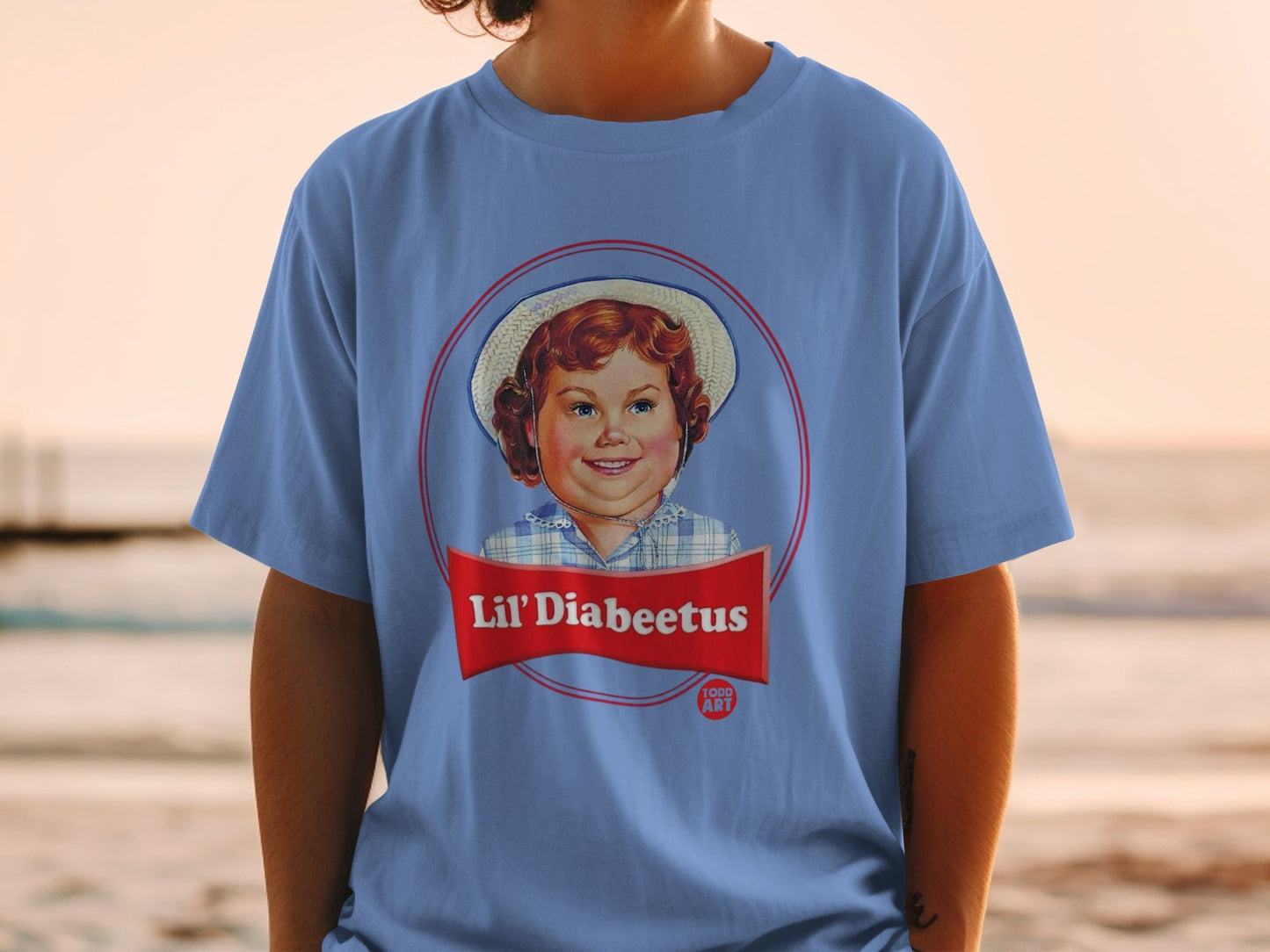 Blue t-shirt with a retro circular logo featuring a smiling child and "Lil' Diabeetus" text.