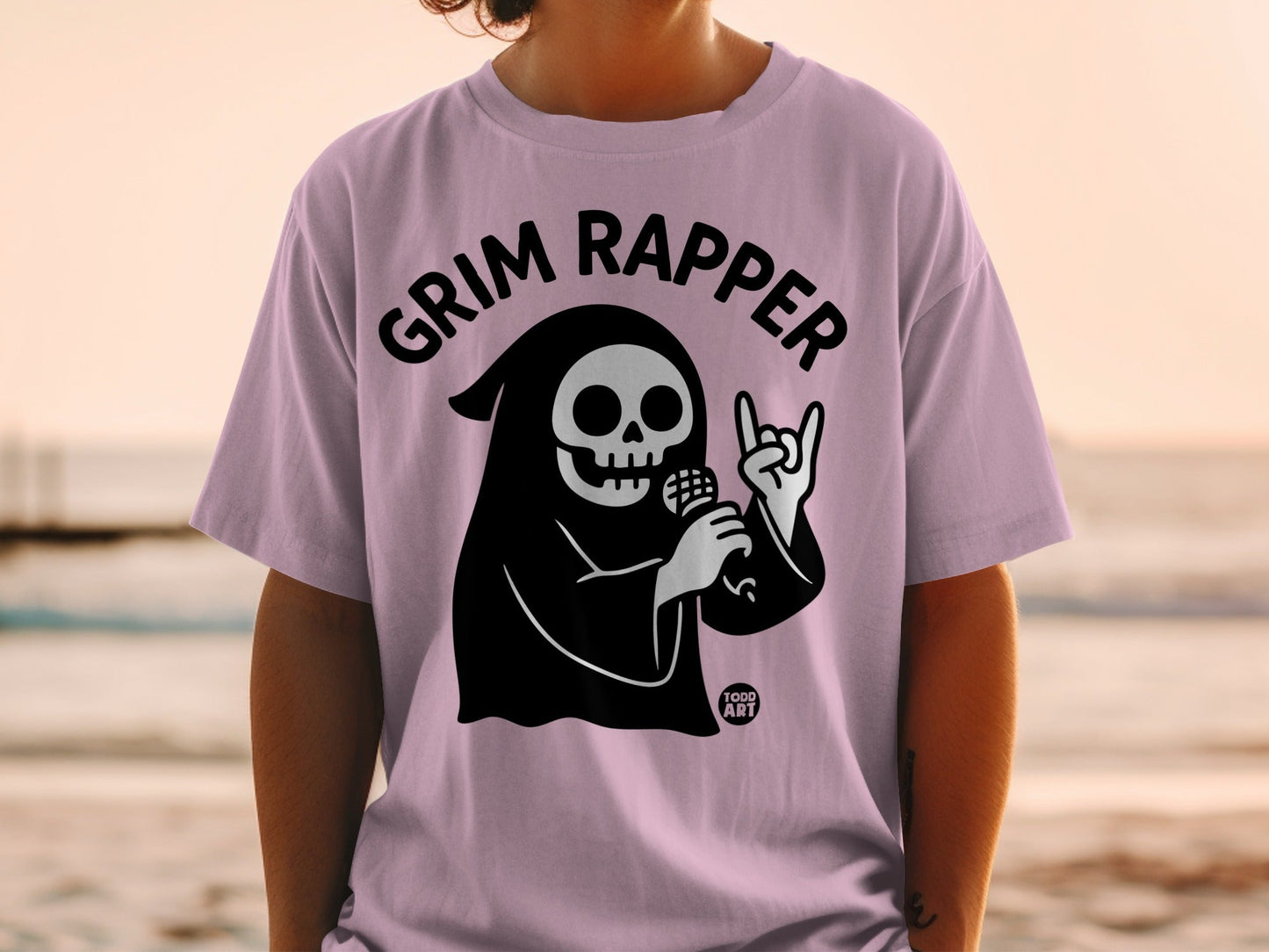 Lilac t-shirt with Grim Reaper holding microphone, rock on hand sign.