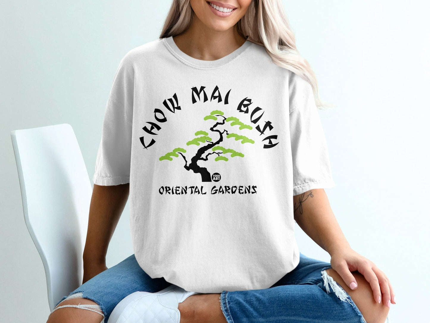 White t-shirt with "CHOW MAI BUSH ORIENTAL GARDENS" and green tree graphic.
