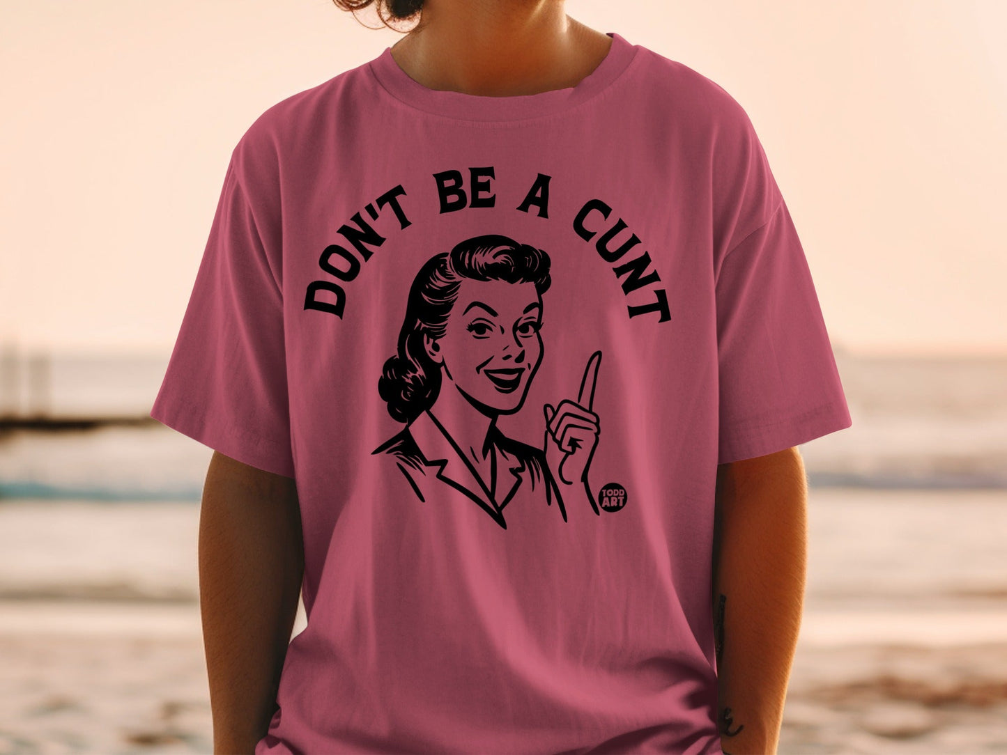 Pink t-shirt with a vintage illustration and text: "DON'T BE A CUNT".