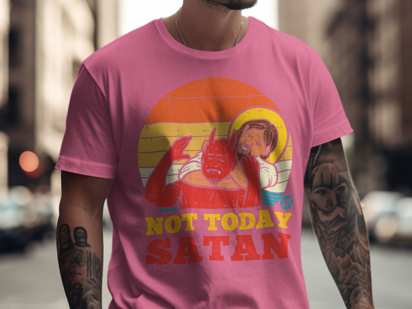 Pink t-shirt with "Not Today Satan" slogan and devil embracing a haloed figure.