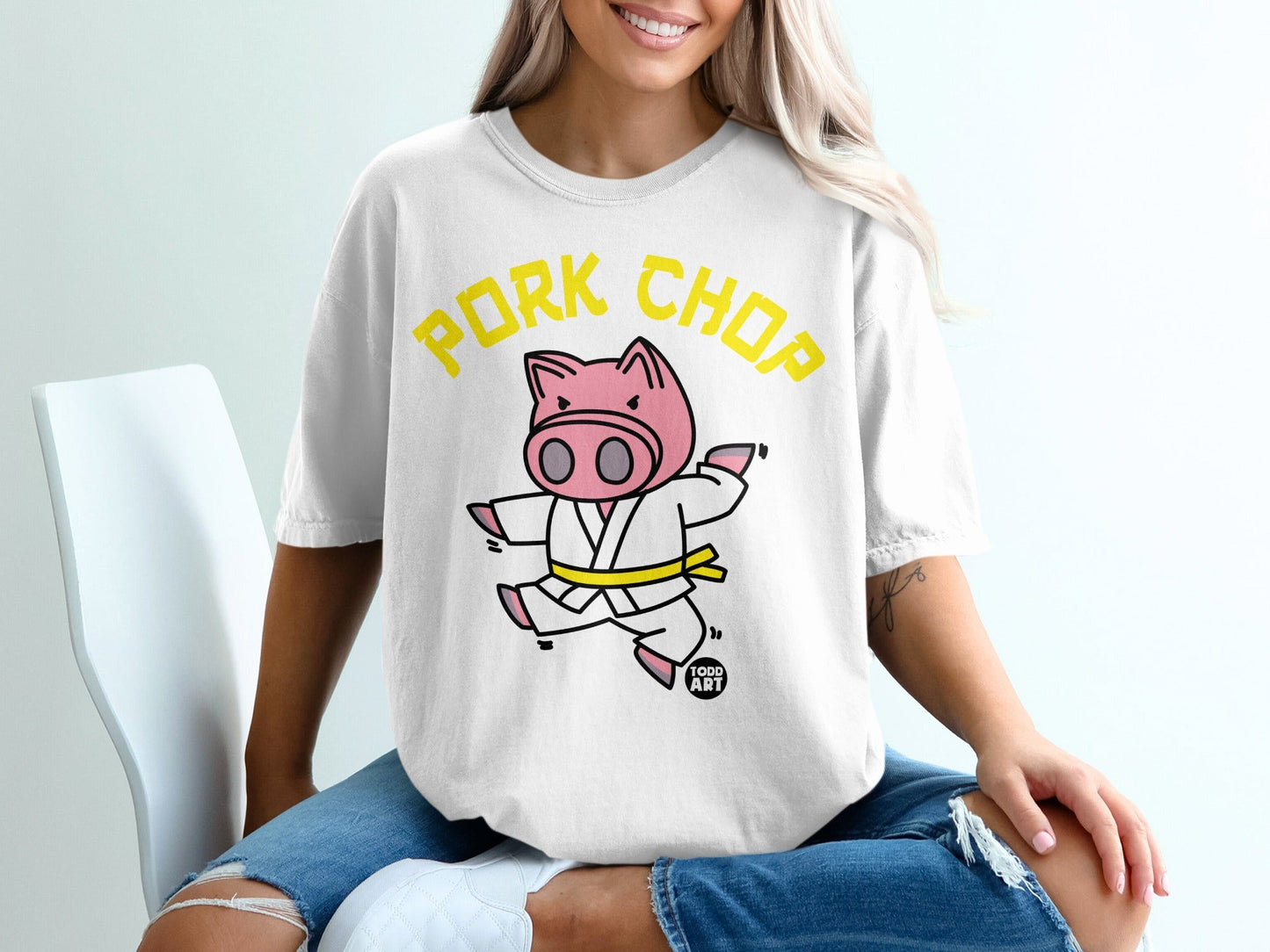 White t-shirt with yellow "Pork Chop" text and cartoon pig in karate gi.
