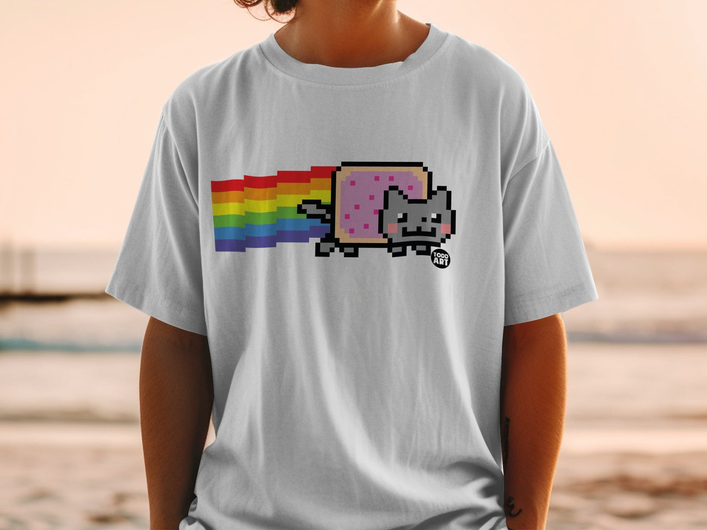 Pixel art Nyan Cat with rainbow trail on a white t-shirt.