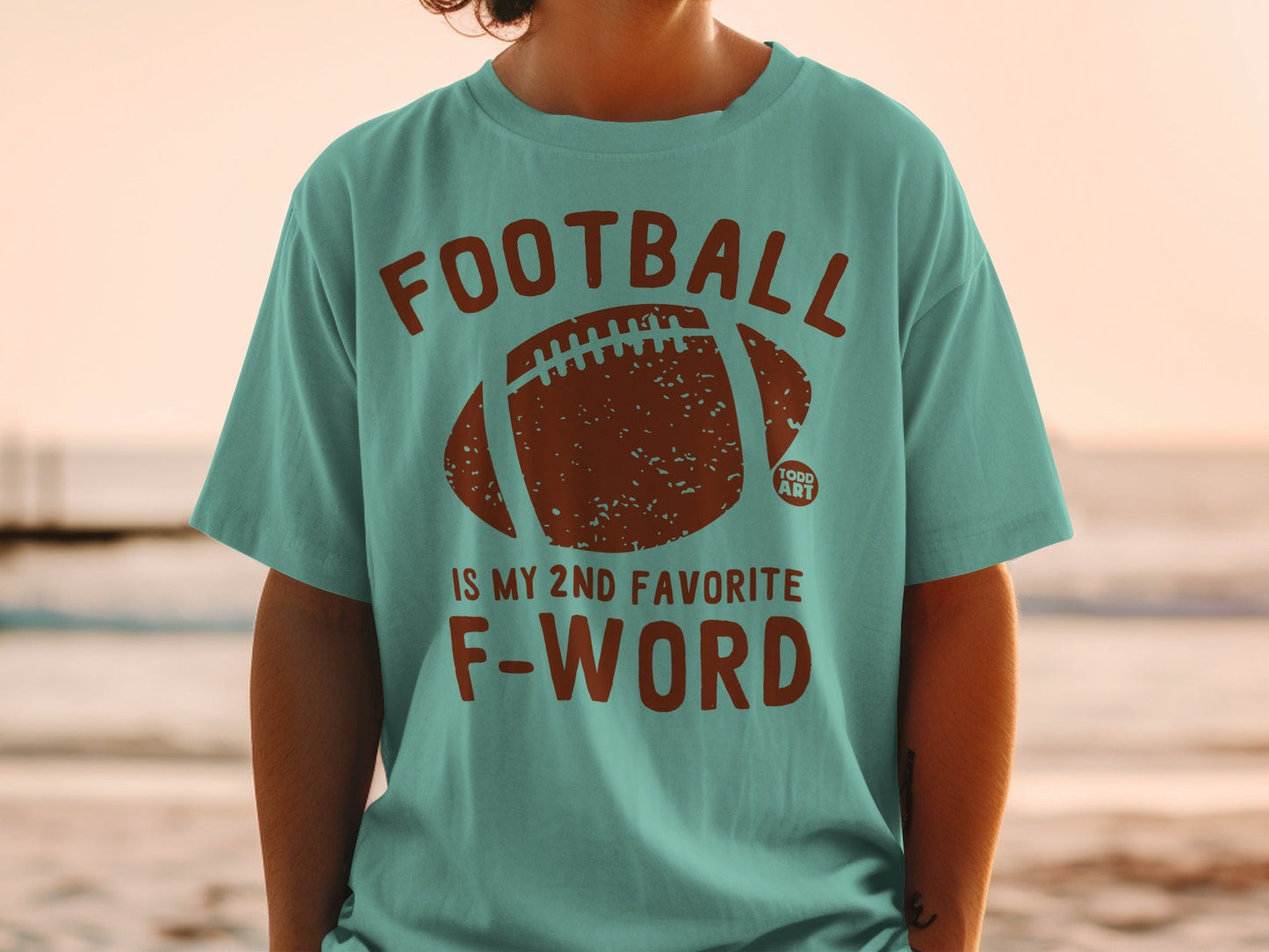 Teal t-shirt with distressed football graphic and "FOOTBALL IS MY 2ND FAVORITE F-WORD" text.