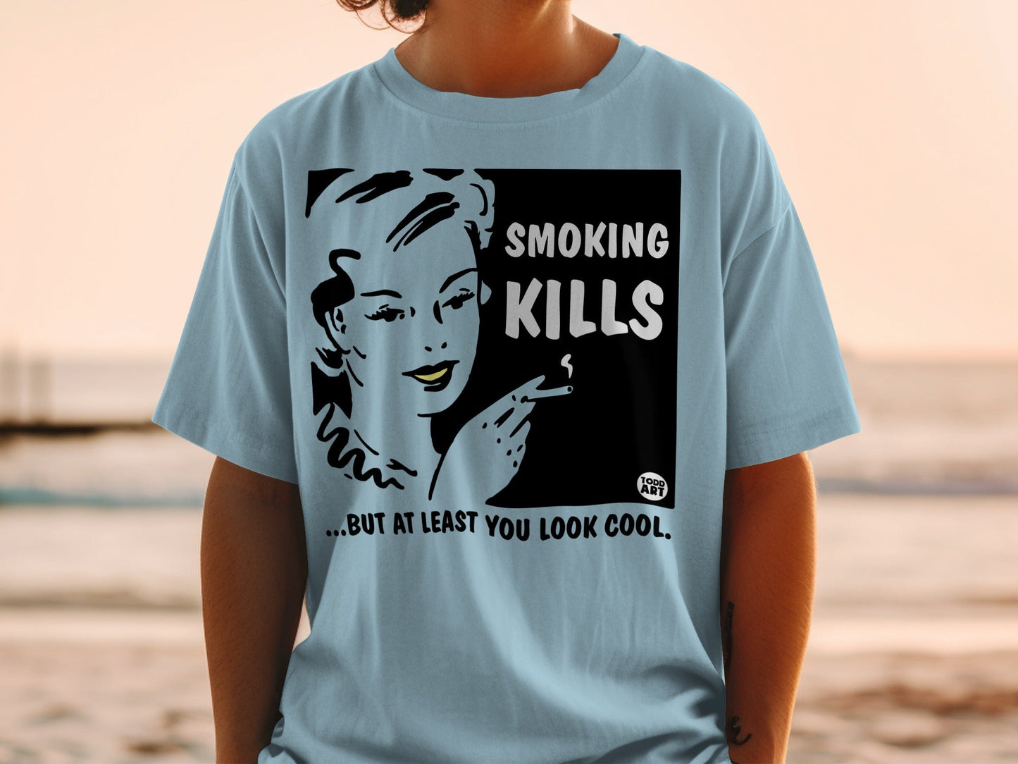 Light blue t-shirt with woman smoking, "Smoking Kills...but at least you look cool."