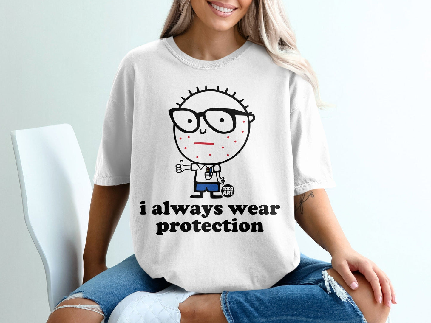 White t-shirt with cartoon character giving thumbs up and text "i always wear protection".