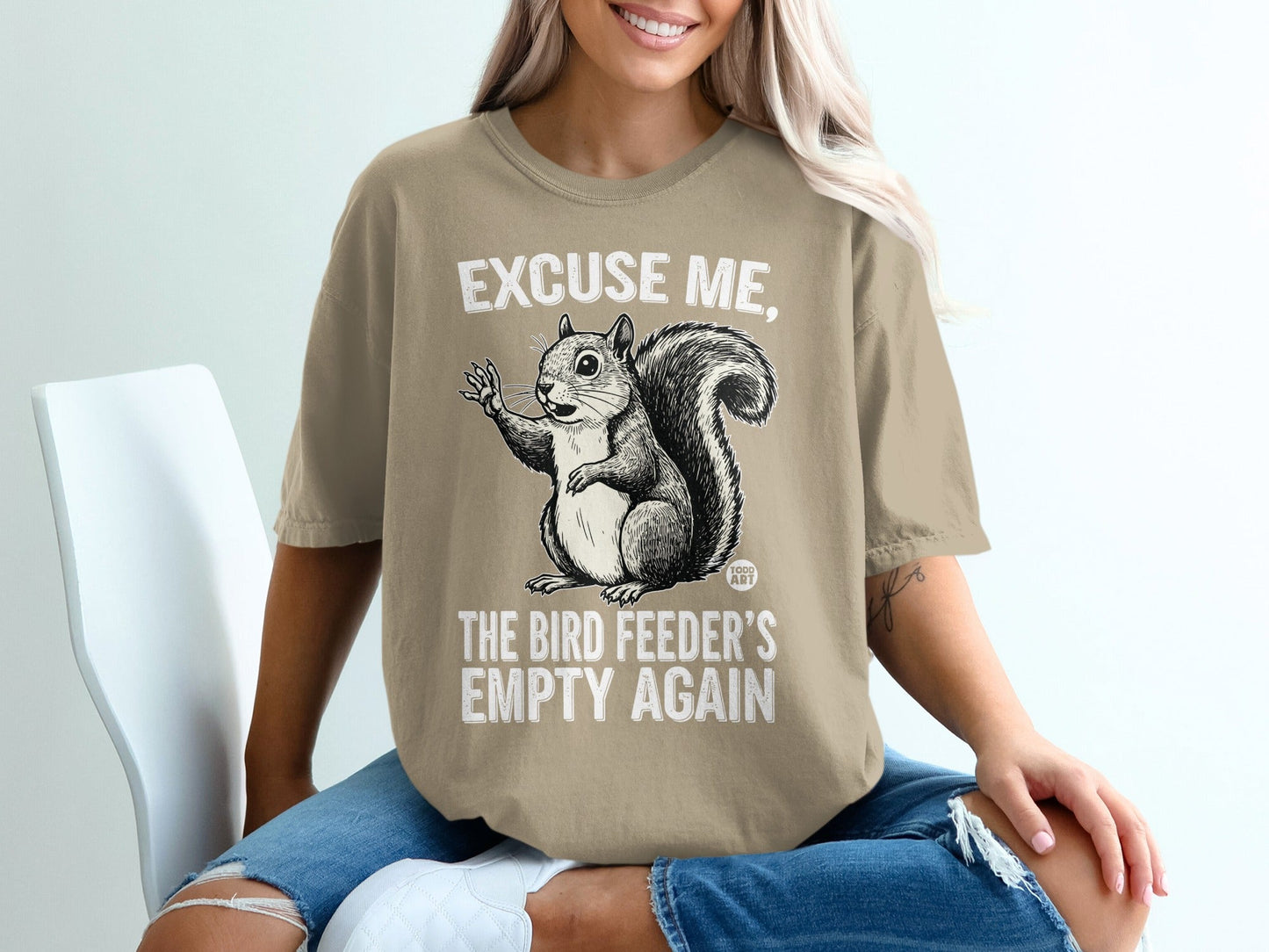 T-shirt graphic of a squirrel with text "Excuse me, the bird feeder's empty again."