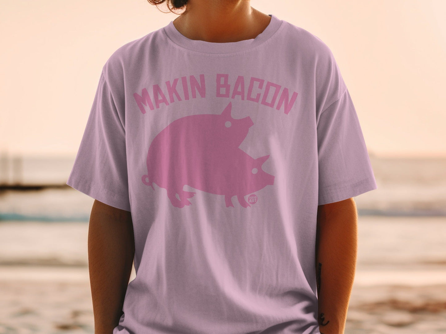 Pink t-shirt with "Makin Bacon" text and two pigs.