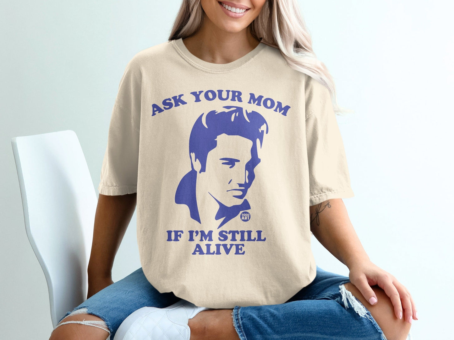 Cream t-shirt with "Ask your mom if I'm still alive" and Elvis Presley graphic.