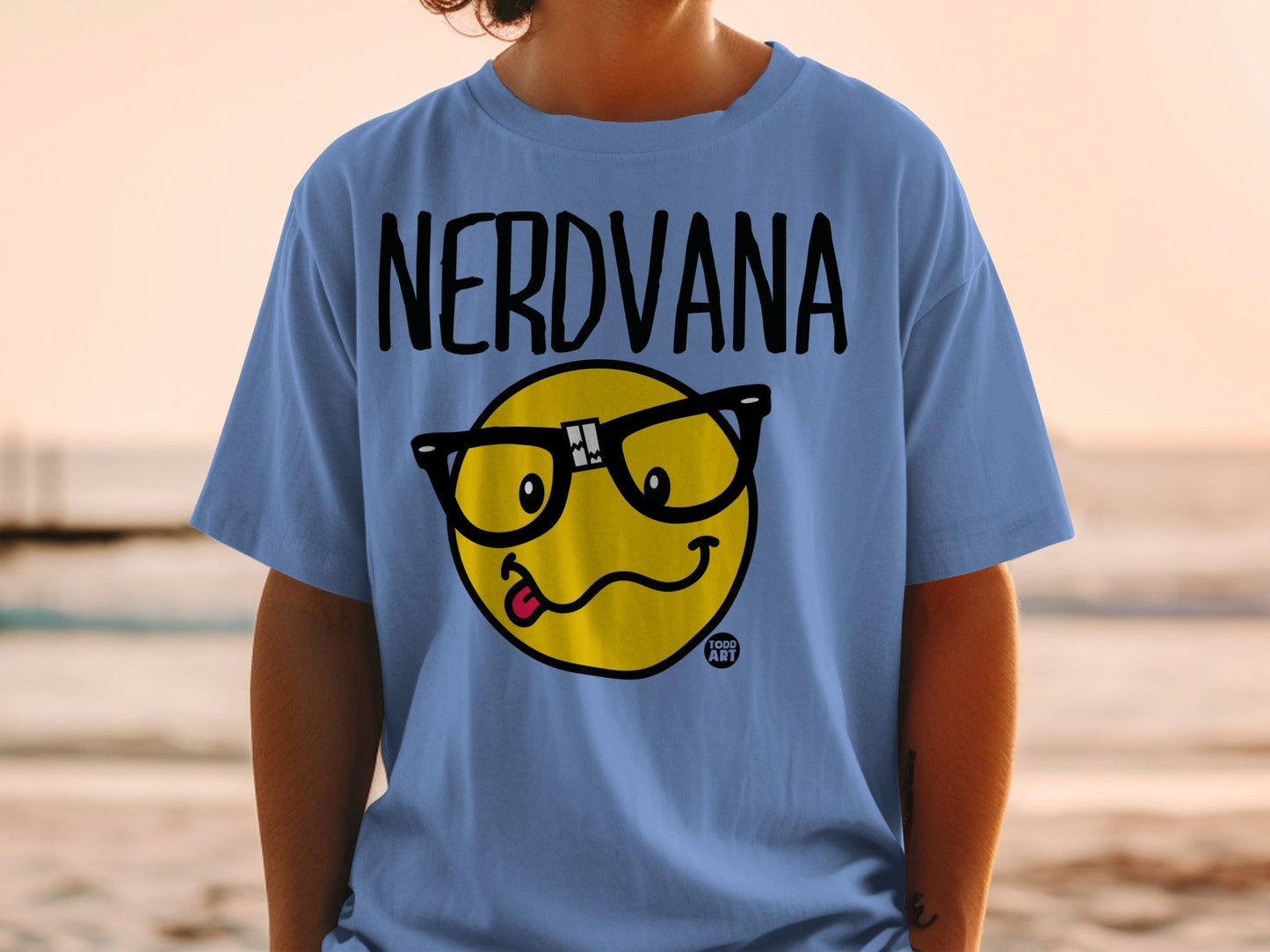 Blue t-shirt with black "NERDVANA" text and a yellow emoji with glasses and tongue out.