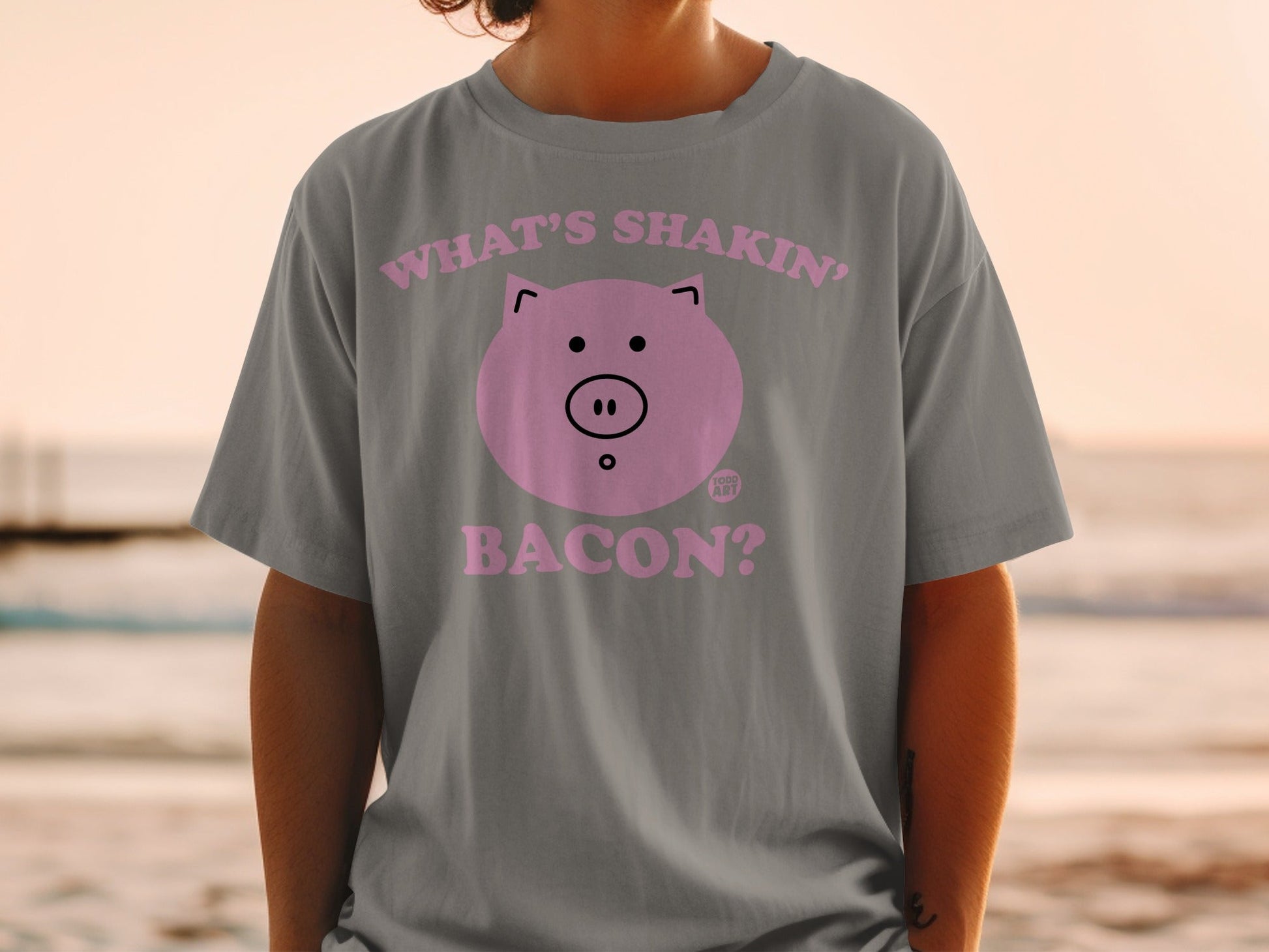 Gray t-shirt with a pink pig face and text "What's shakin' bacon?".