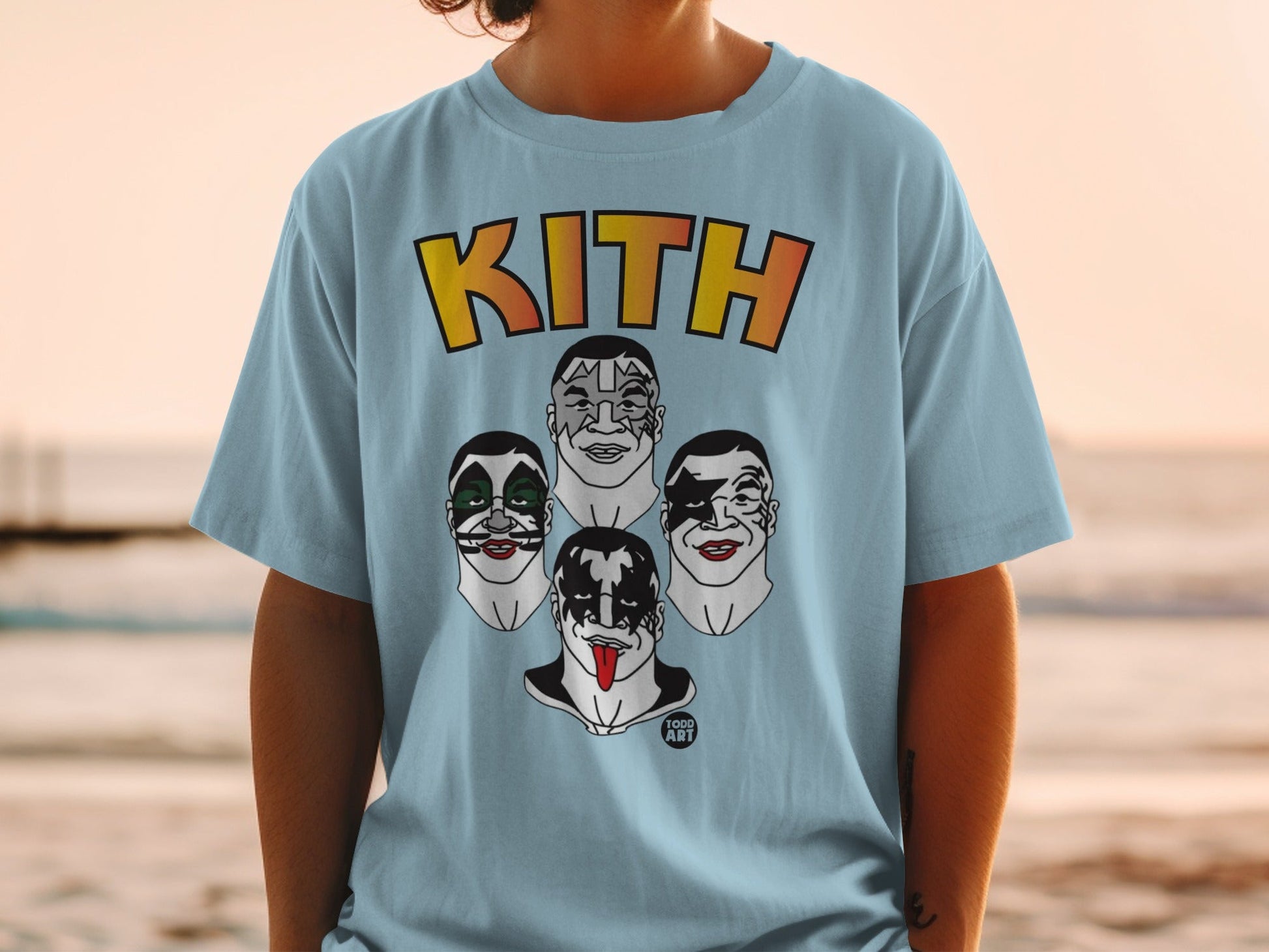 Kith logo above four cartoon faces with heavy makeup on a light blue t-shirt.