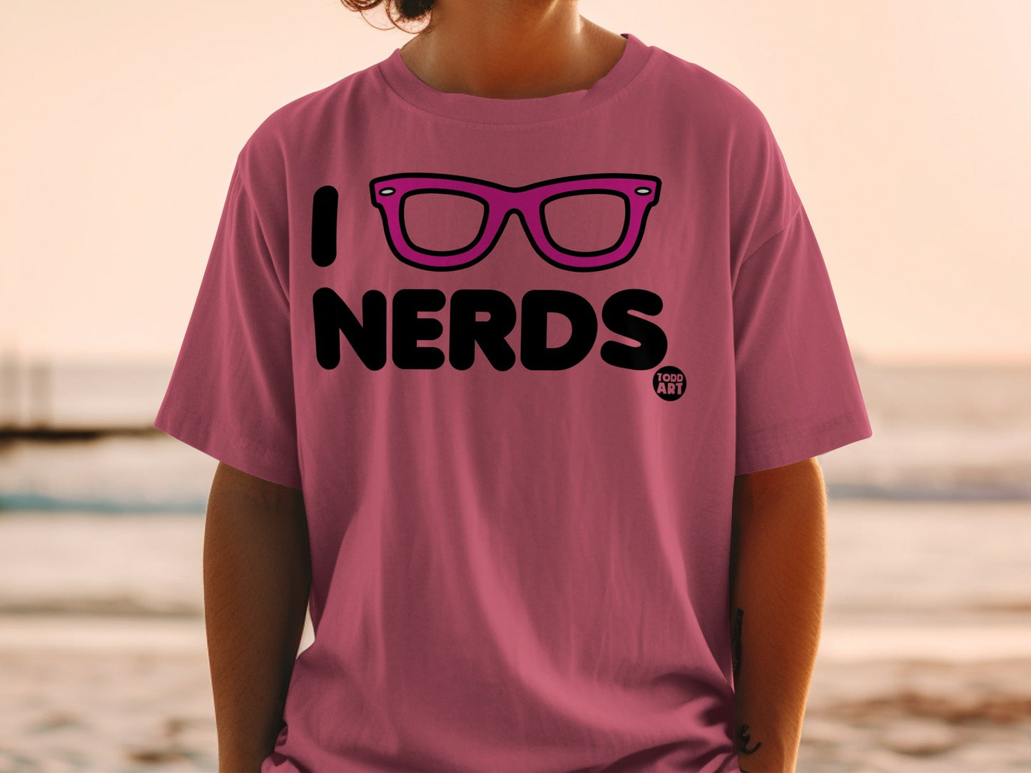 Pink t-shirt with "I [glasses icon] NERDS" and "TODD ART" logo.