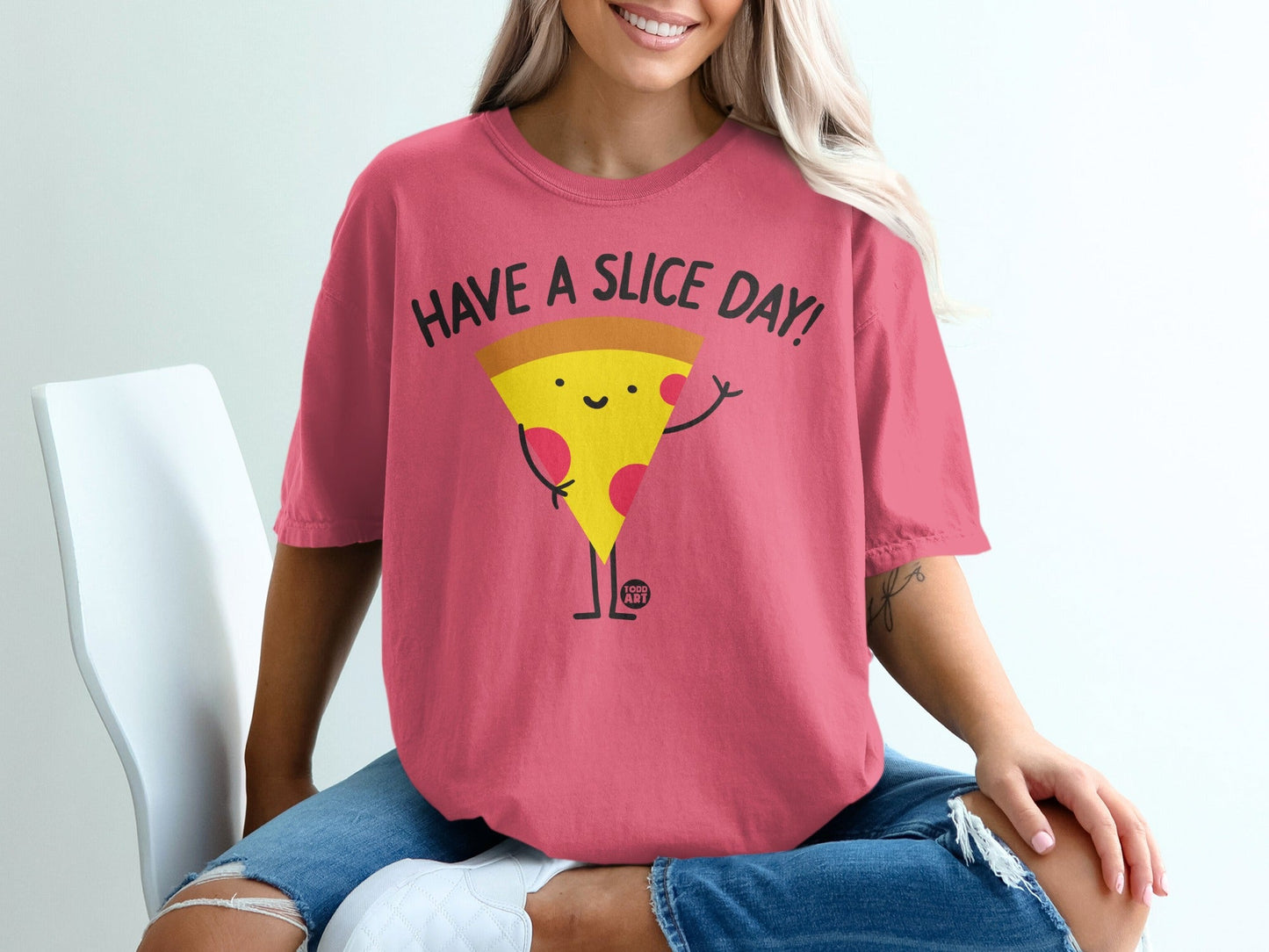 Pink t-shirt with smiling pizza graphic saying "HAVE A SLICE DAY!".