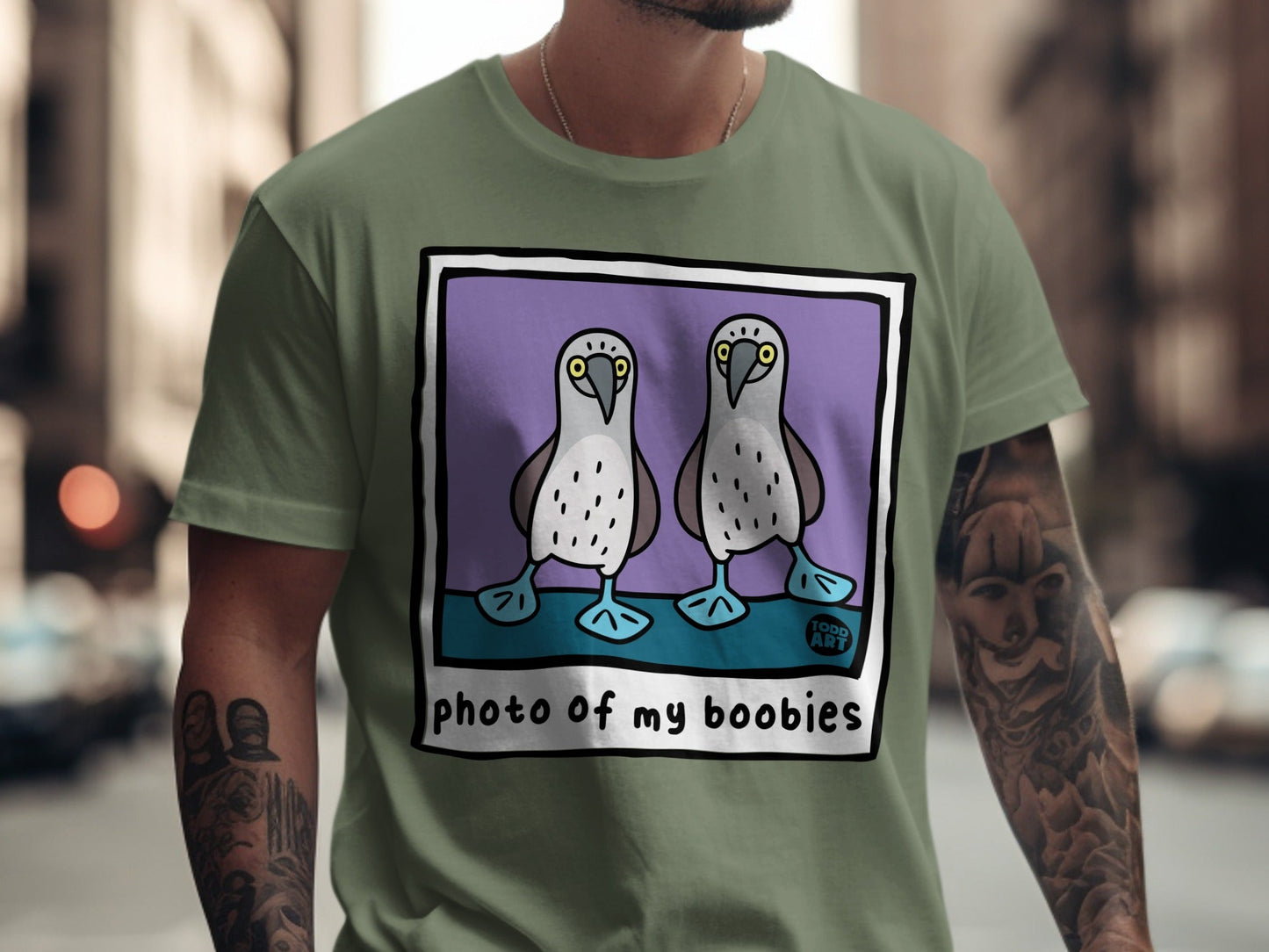 Green t-shirt with illustration of two blue-footed boobies and text "PHOTO OF MY BOOBIES".