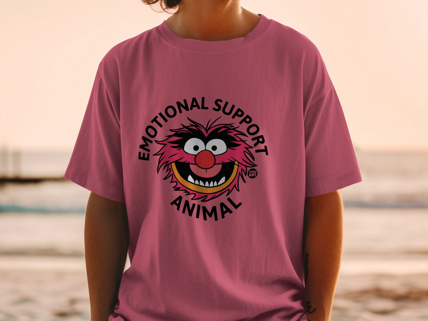 Pink t-shirt with "Emotional Support Animal" text and cartoon character graphic.