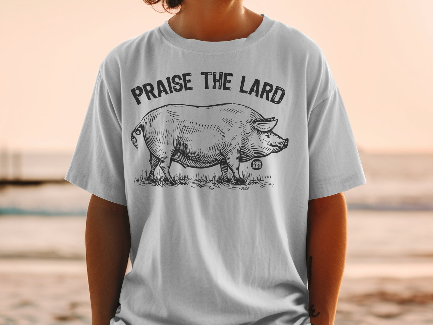 Light grey t-shirt with a sketch of a pig and text "PRAISE THE LARD".