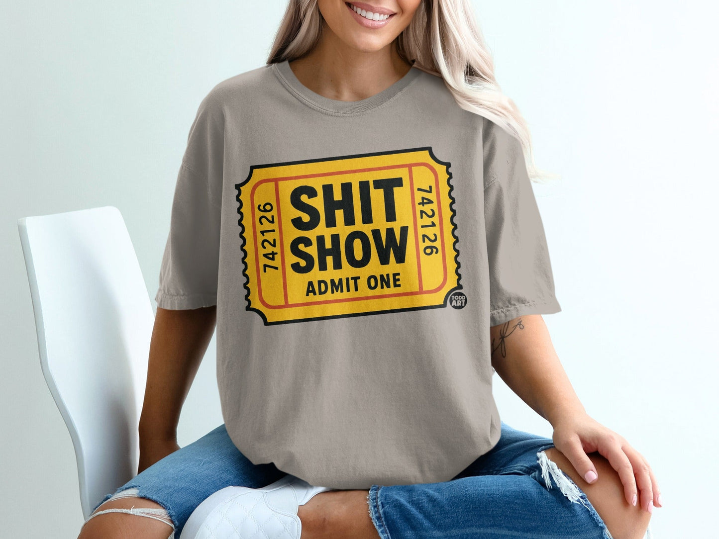 Ticket-style graphic on a grey t-shirt: "SHIT SHOW ADMIT ONE".