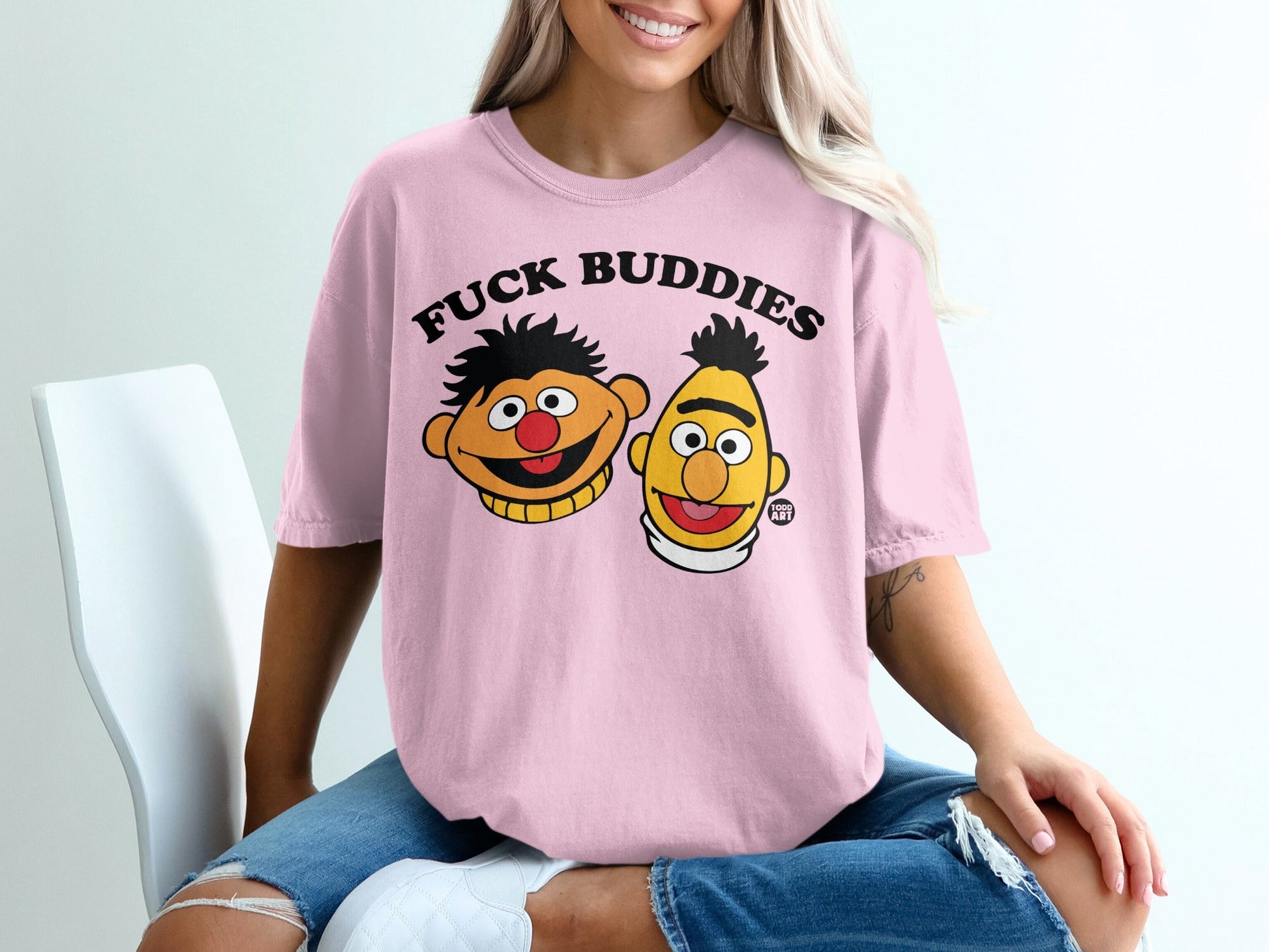 Pink t-shirt with cartoon faces of Ernie and Bert from Sesame Street.