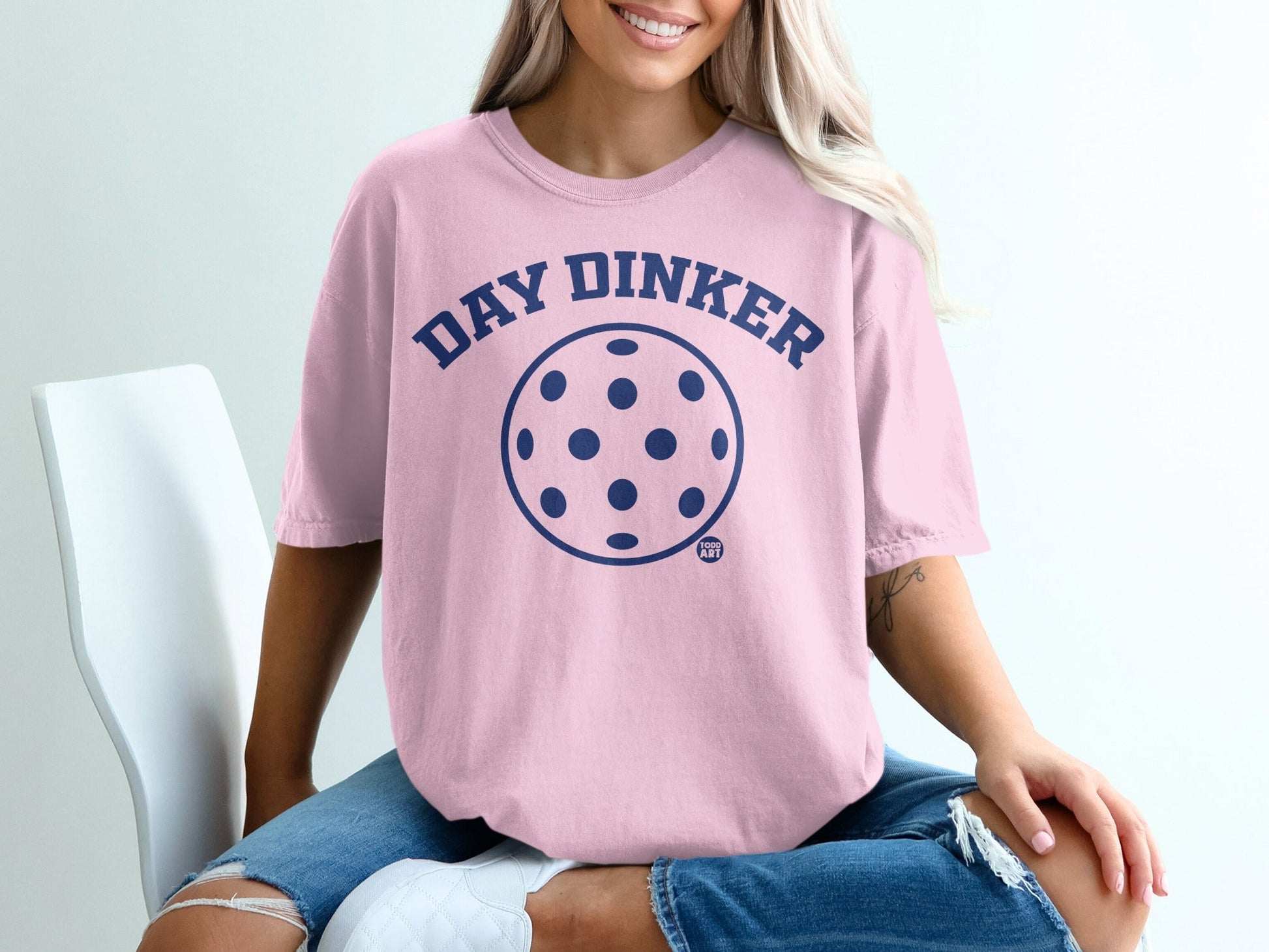 Pink t-shirt with navy blue "Day√∂lker" text and pickleball graphic.