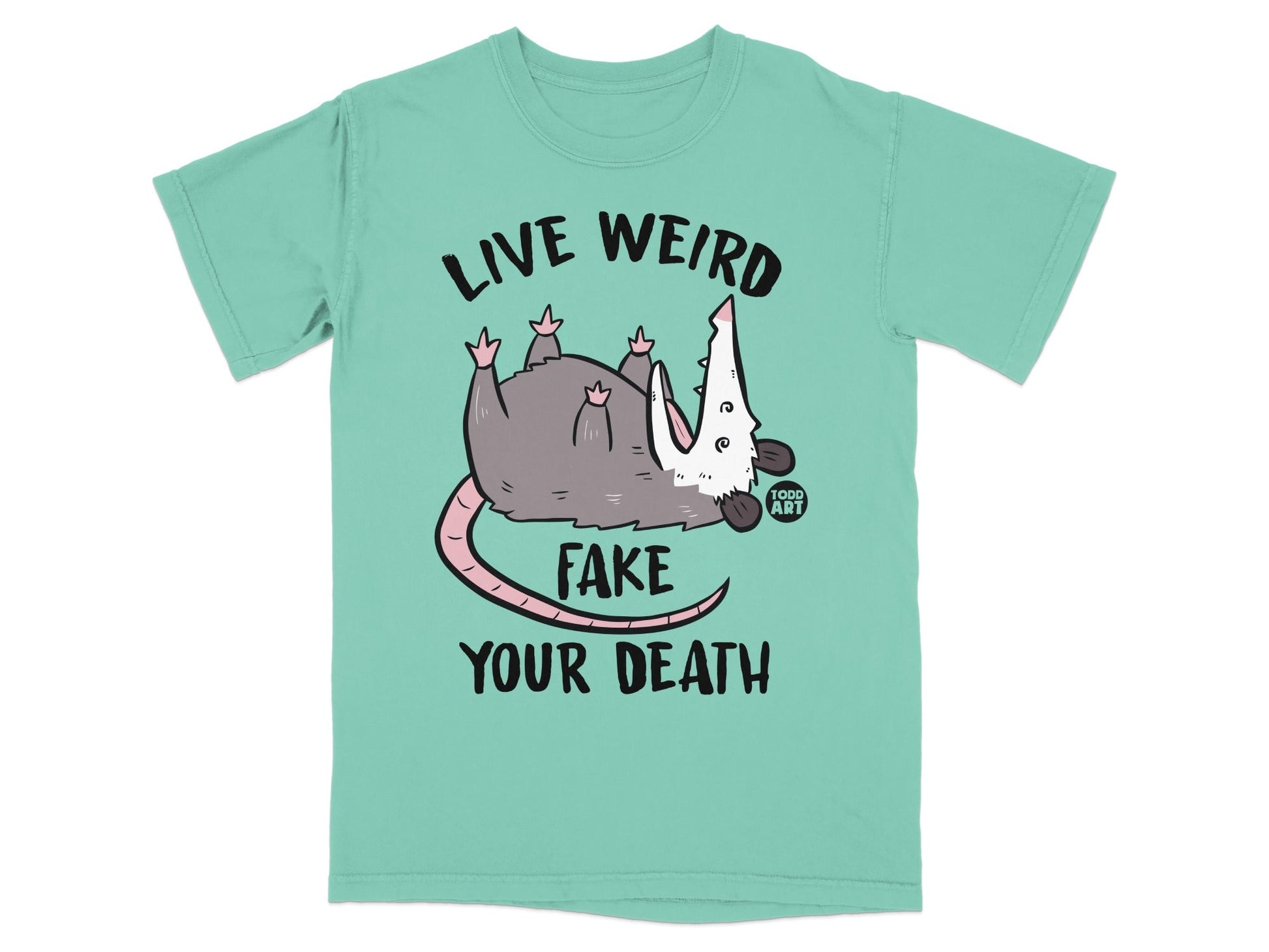 Opossum wearing shirt with "LIVE WEIRD FAKE YOUR DEATH" text.