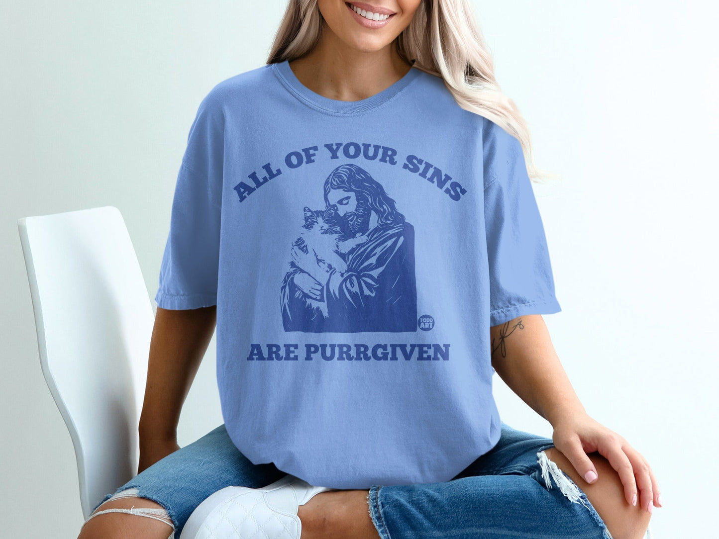 Light blue t-shirt with Jesus holding a cat and text "ALL OF YOUR SINS ARE PURRGIVEN".