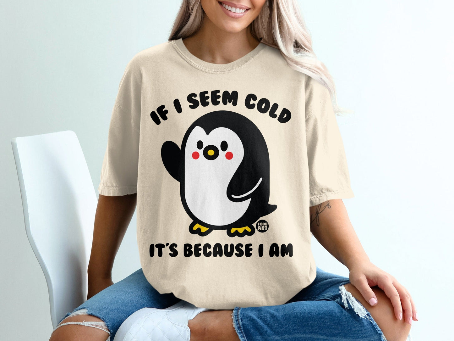 Penguin graphic on cream t-shirt with text "IF I SEEM COLD IT'S BECAUSE I AM".