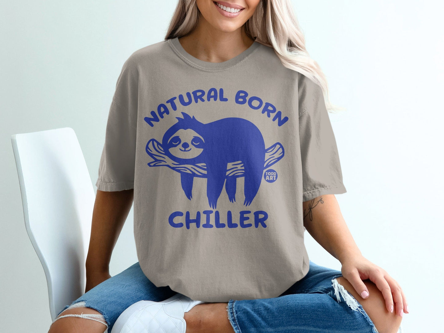 Tan t-shirt with blue sloth graphic and "Natural Born Chiller" text.