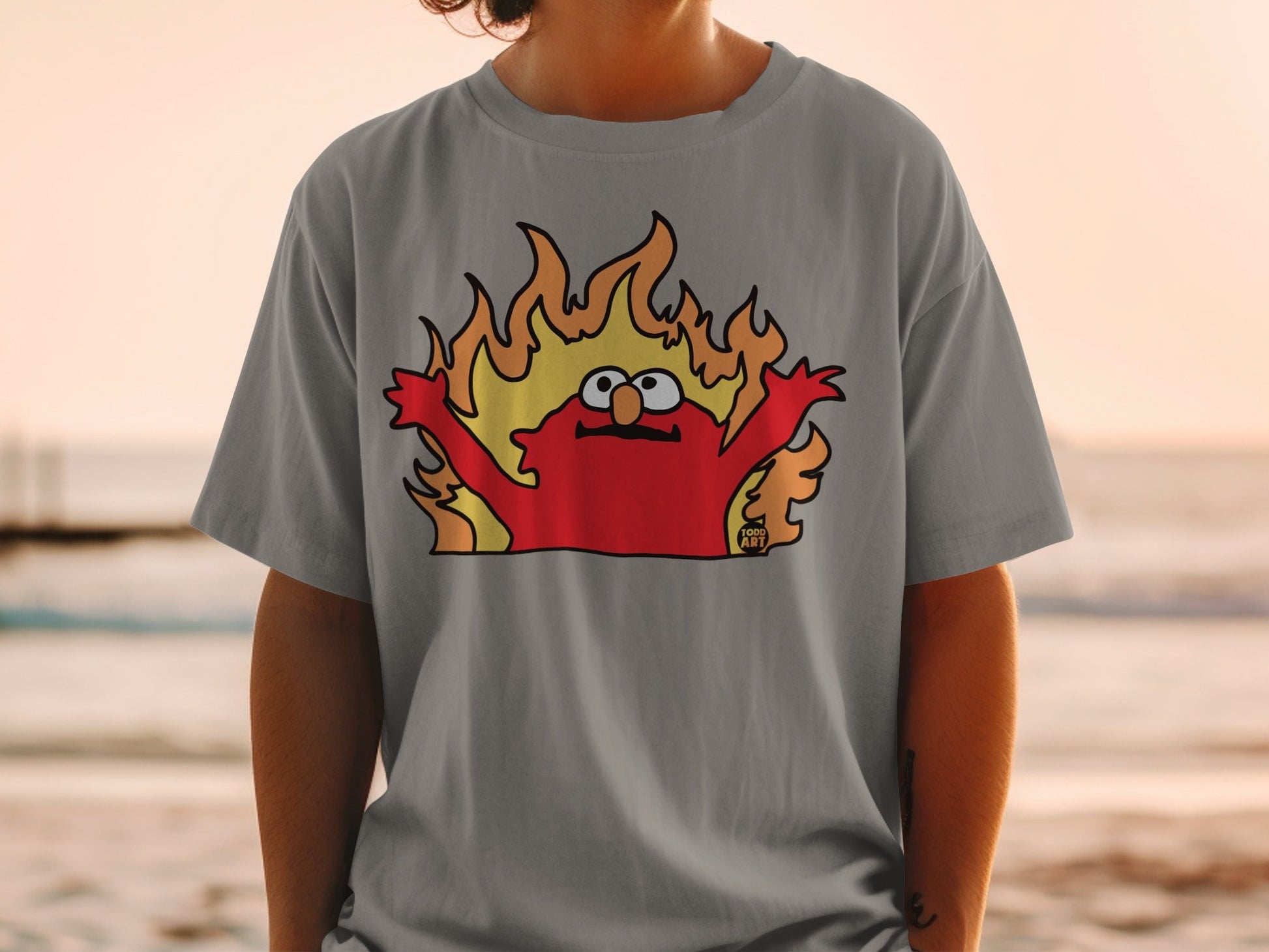 Elmo character on a gray t-shirt engulfed in cartoon flames.