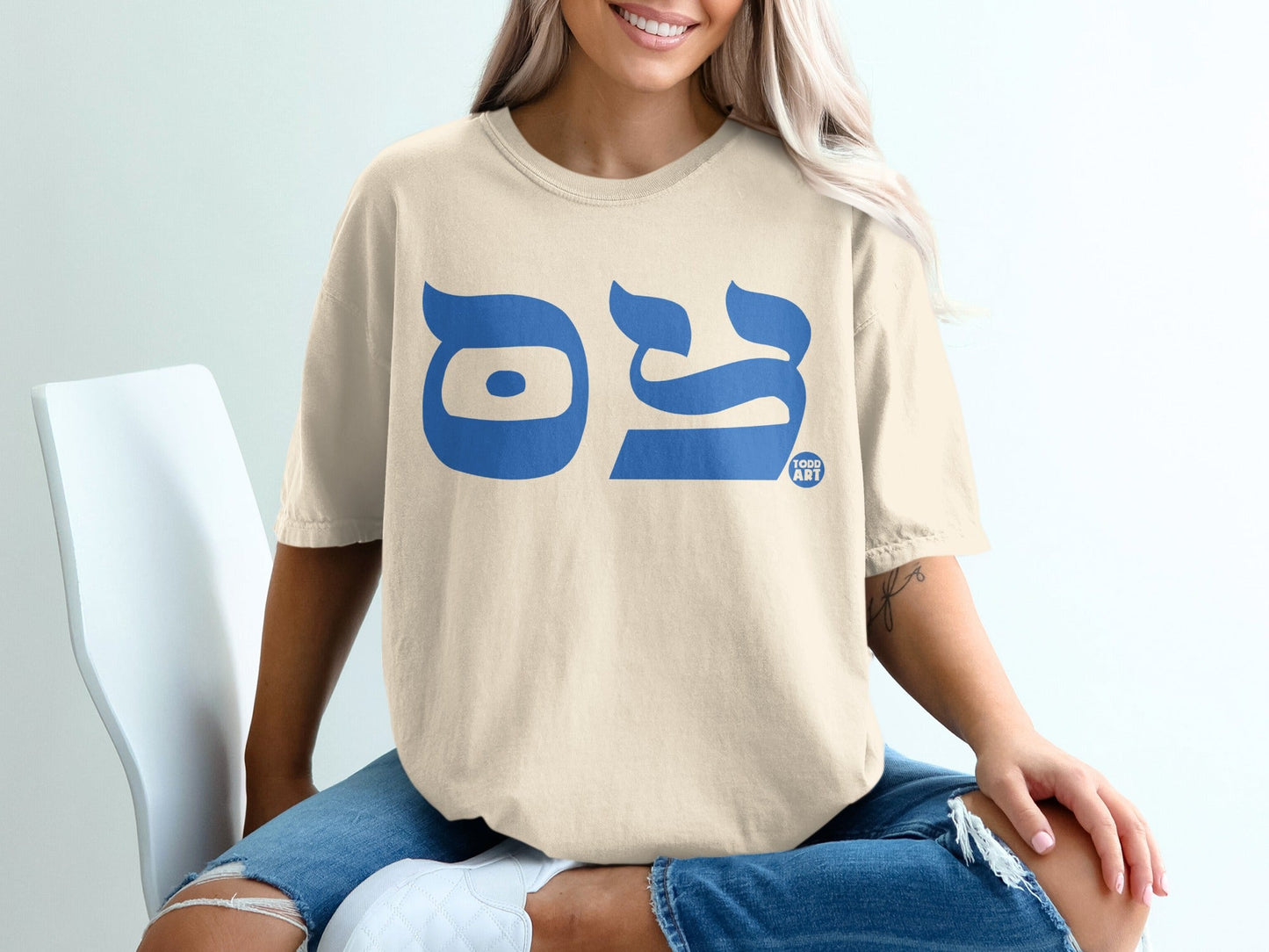 Cream t-shirt with blue Hebrew letters "◊ê◊ï◊®" and "TODD ART" logo.