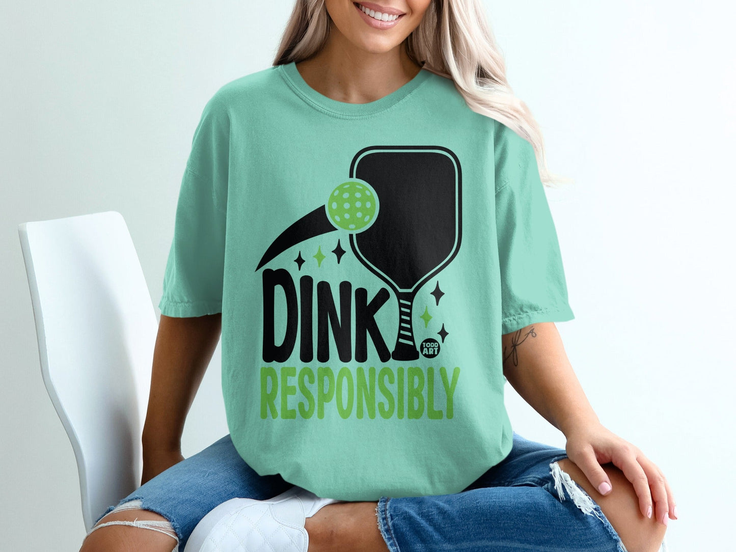 Mint t-shirt with black pickleball paddle, ball, and "DINK RESPONSIBLY" text.