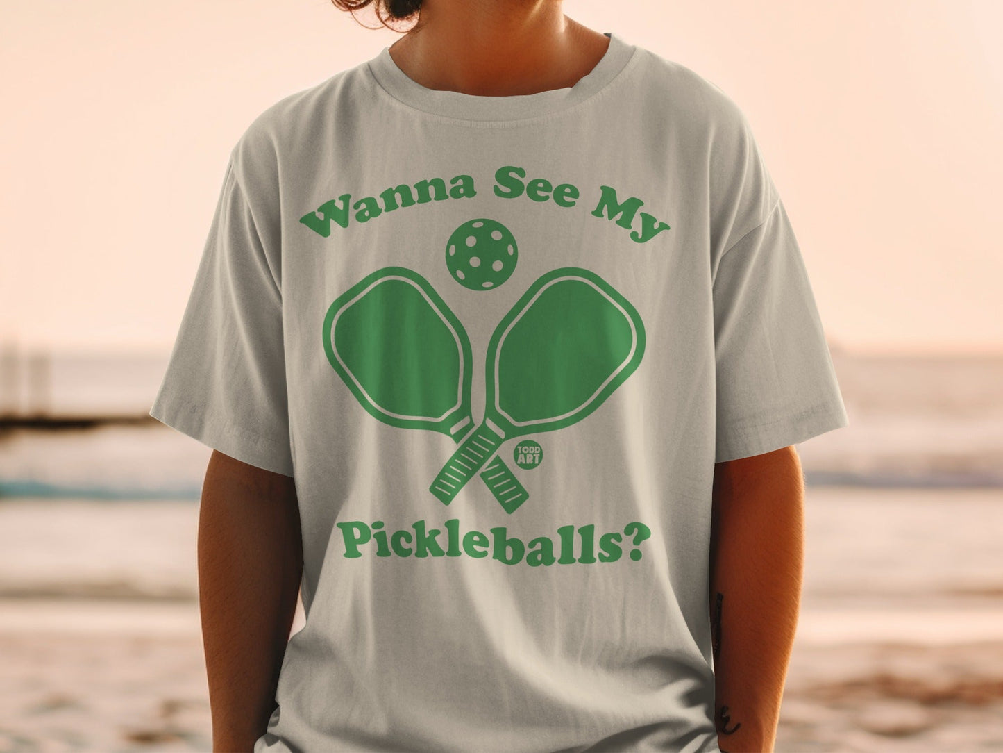 Green graphic t-shirt with "Wanna See My Pickleballs?" text and pickleball paddle and ball.