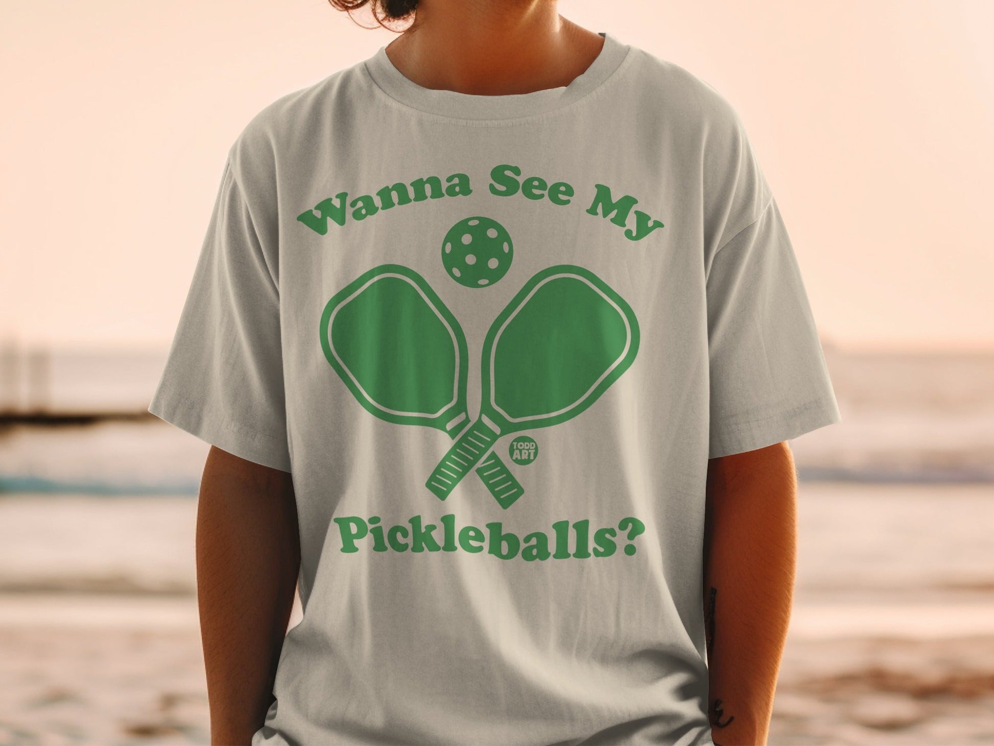 Green graphic t-shirt with "Wanna See My Pickleballs?" text and pickleball paddle and ball.