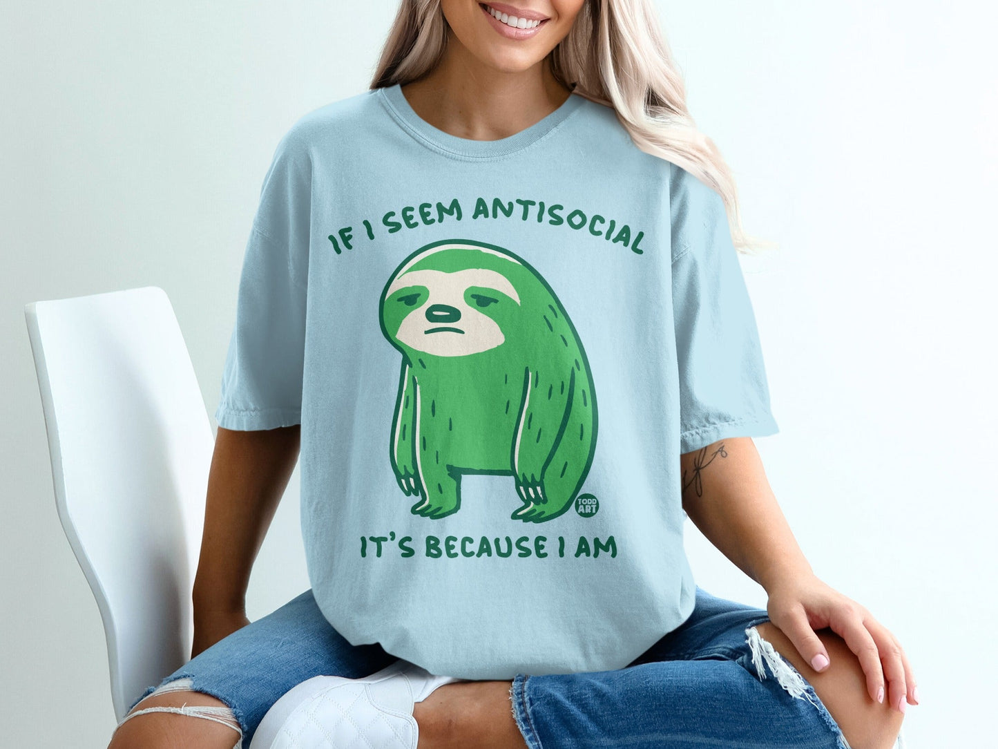 Light blue t-shirt with a green sloth graphic and text.