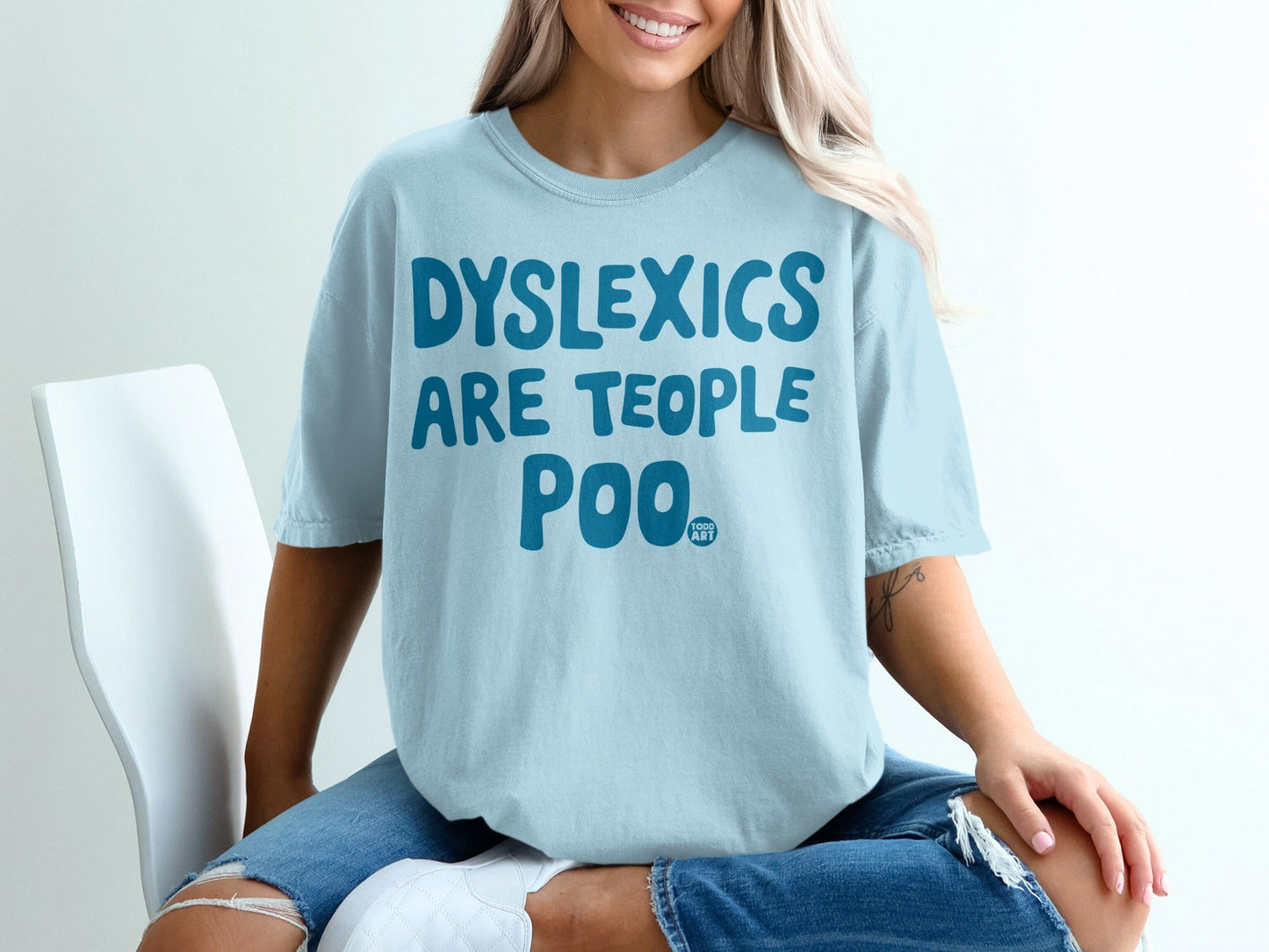 Light blue t-shirt with "DYSLEXICS ARE PEOPLE TOO" and "GOOD ART" text.