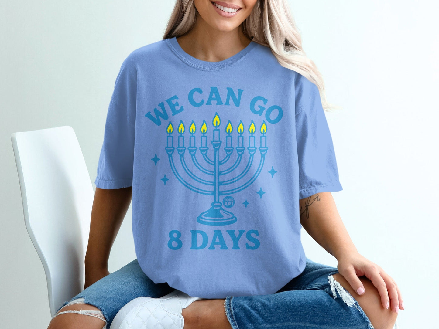 Light blue t-shirt with a menorah and text "WE CAN GO 8 DAYS".