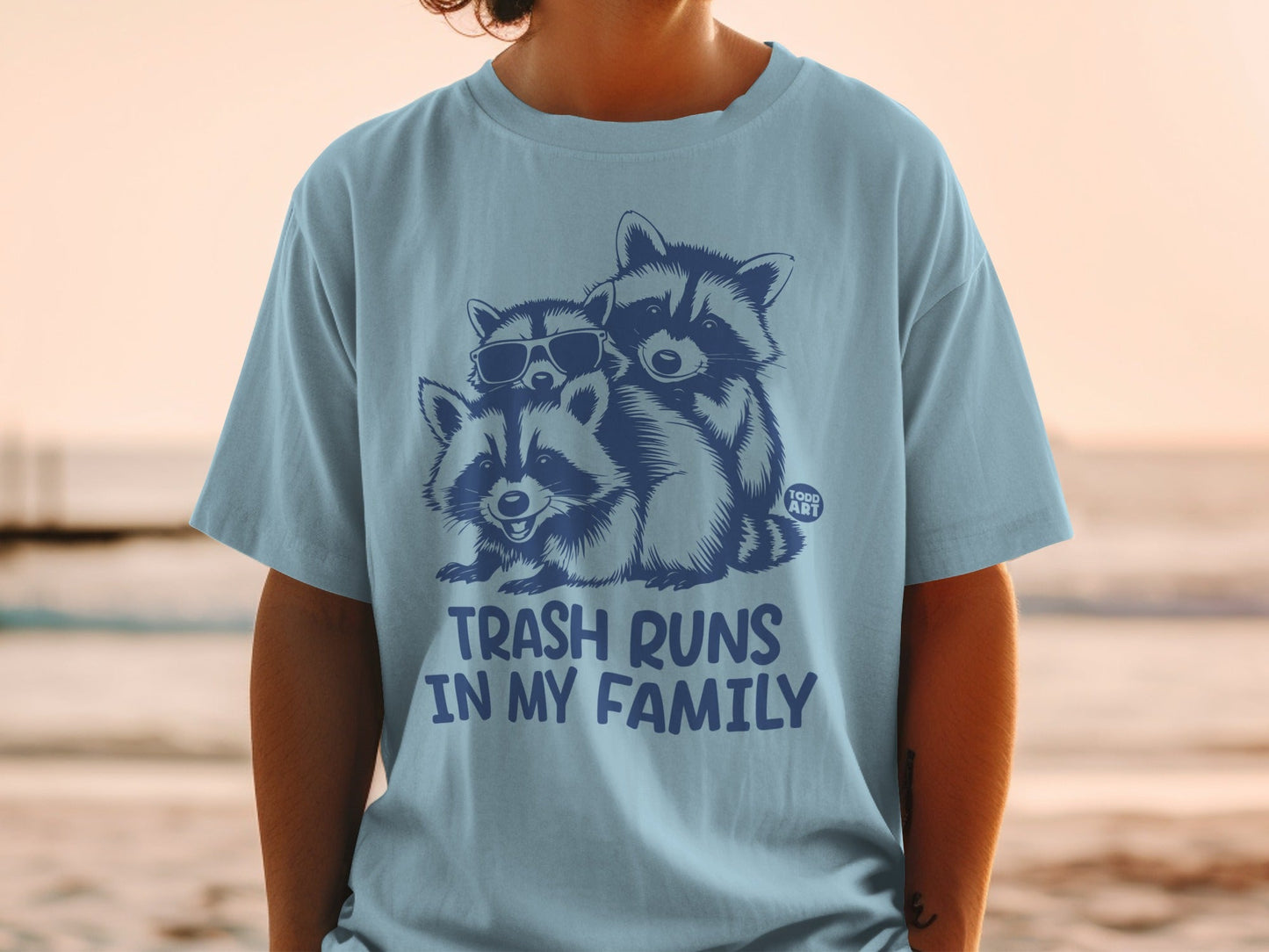 T-shirt with three raccoons wearing sunglasses and the text "Trash Runs In My Family."