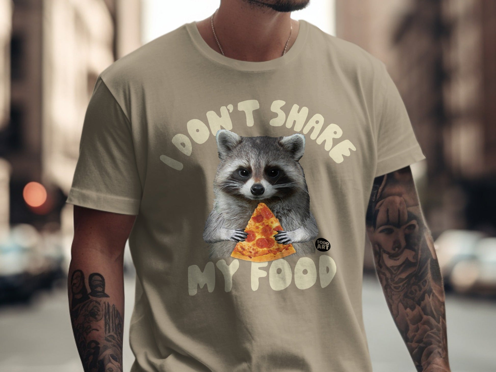 Tan t-shirt with raccoon holding a slice of pizza and text "I DON'T SHARE MY FOOD".