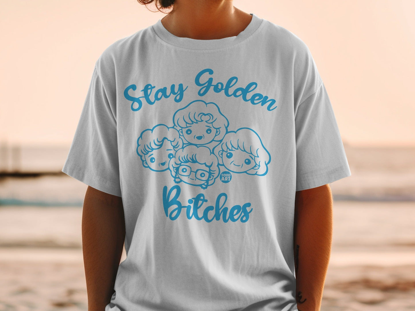 White t-shirt with "Stay Golden Bitches" and cartoon faces of four women.