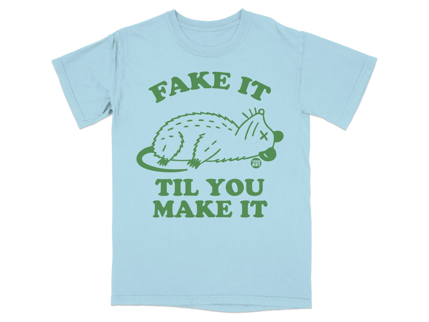 Light blue t-shirt with "FAKE IT TIL YOU MAKE IT" and a stylized opossum graphic.