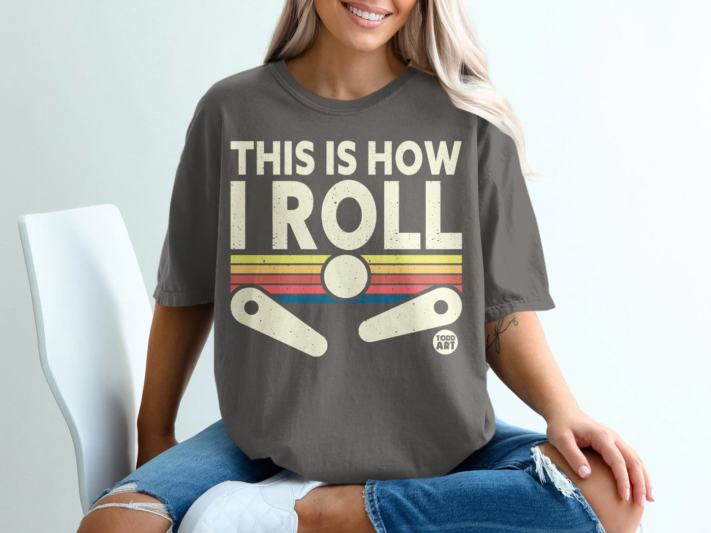 Dark gray t-shirt with "THIS IS HOW I ROLL" and pinball graphic.