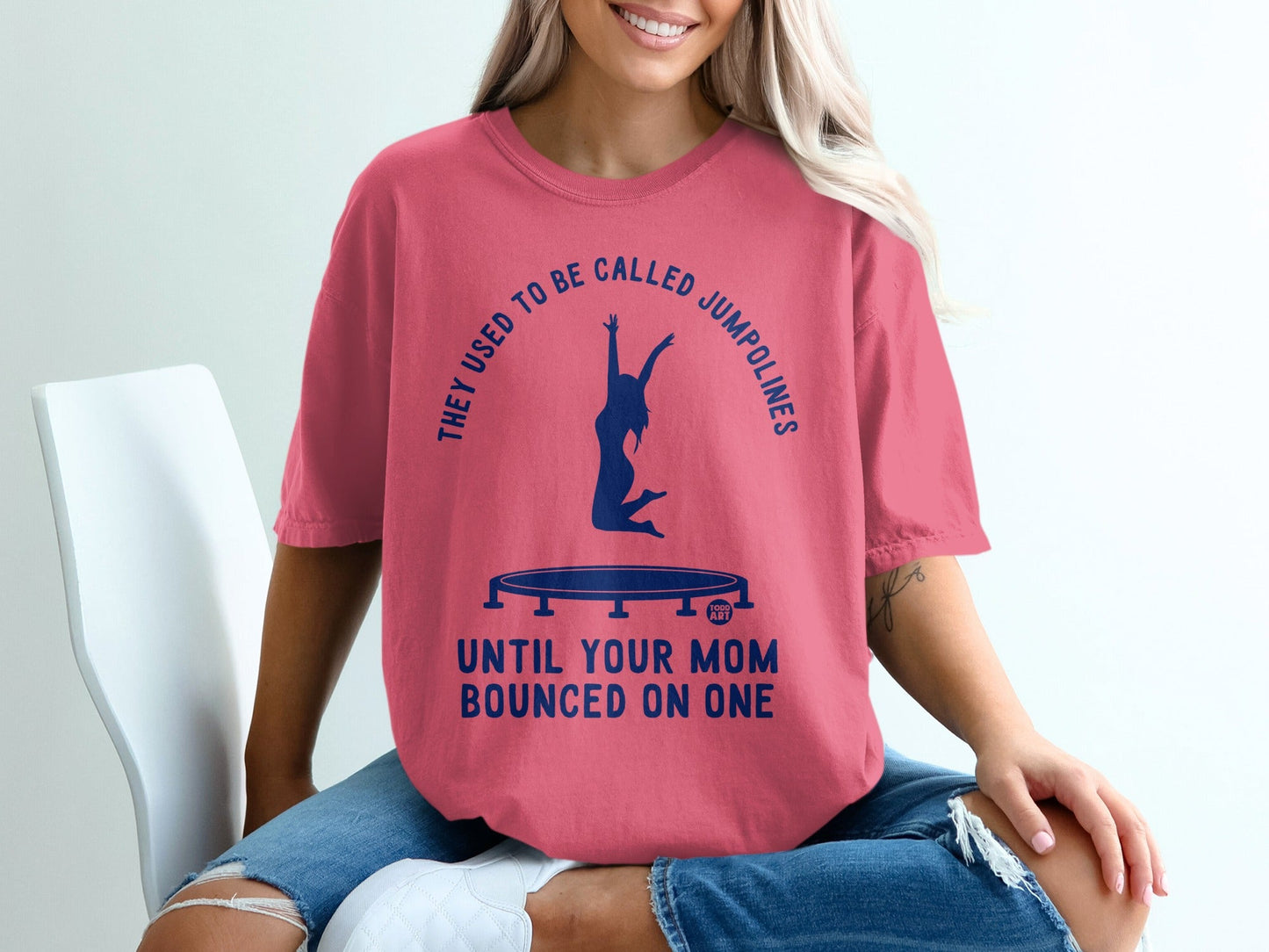 Pink t-shirt with graphic: "They used to be called jumpolines until your mom bounced on one"