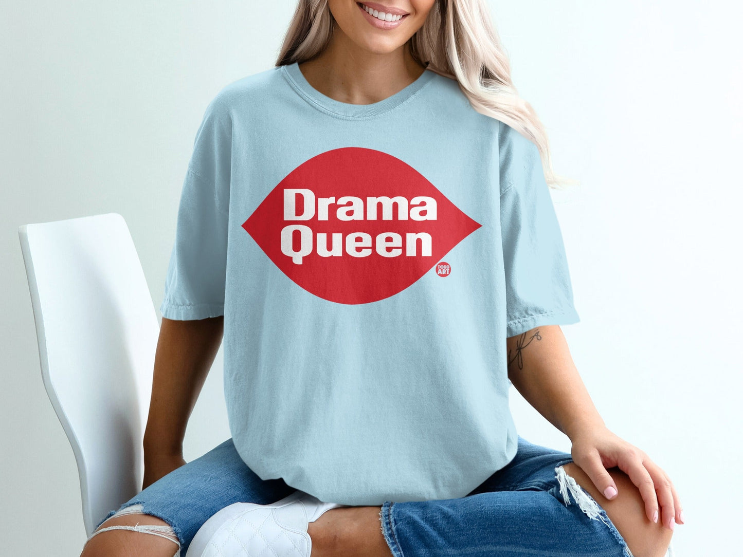 Light blue t-shirt with red "Drama Queen" diamond logo on chest.