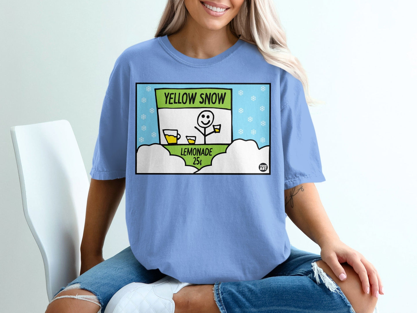 T-shirt with cartoon lemonade stand and snowflakes, reads "Yellow Snow Lemonade 25¬¢".
